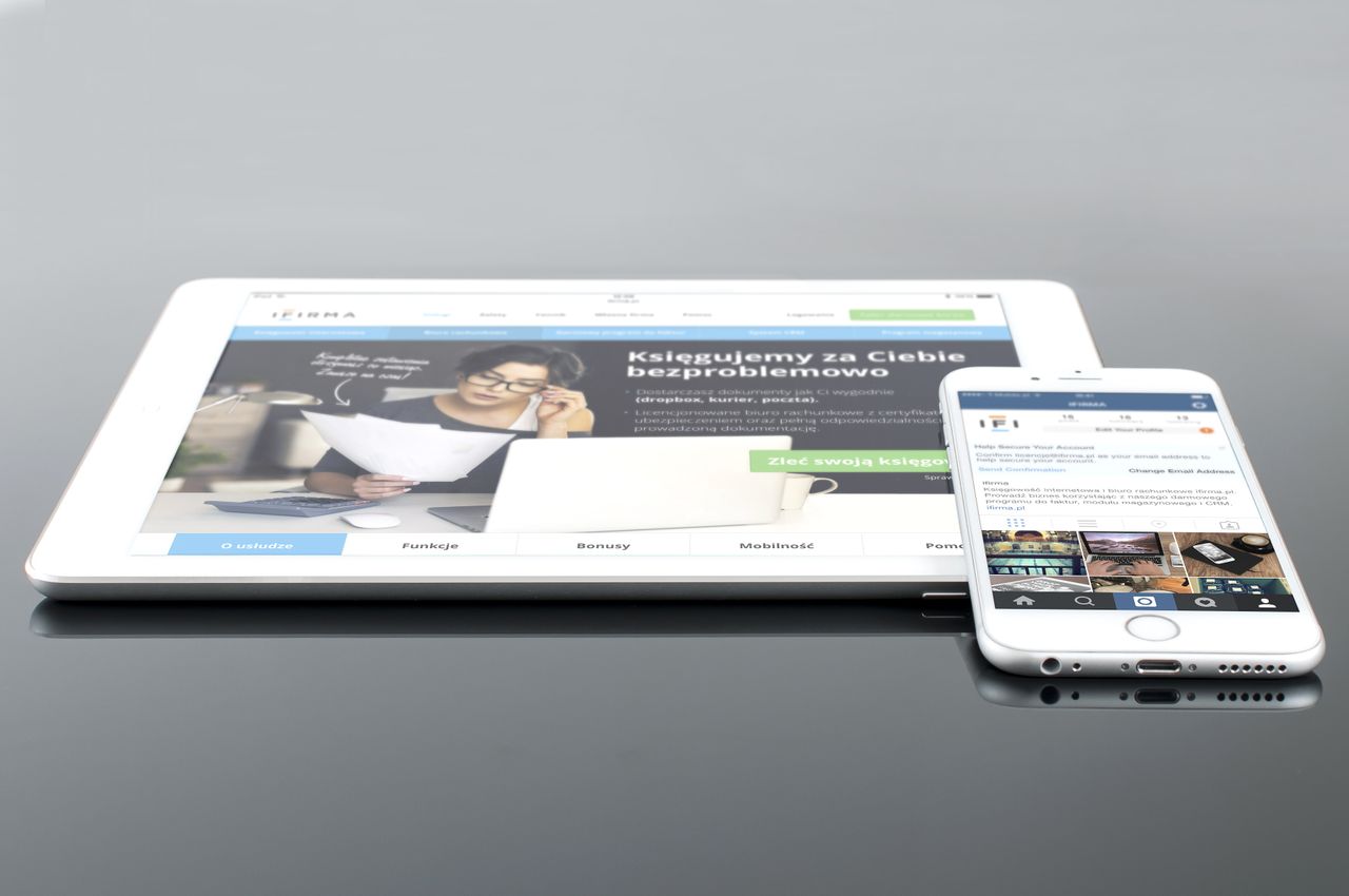 role-01 Modern tablet and smartphone displaying web content on a reflective surface, highlighting technology and connectivity.